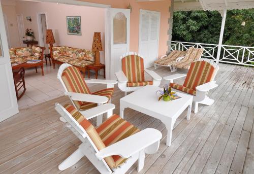 Black Rock朴浪嗒雄海滩别墅的门廊配有椅子、桌子和沙发