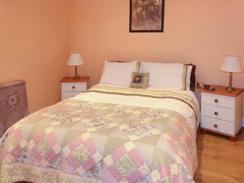 KnockThe Lake House, Connemara的一间卧室配有一张带2个床头柜和2盏灯的床。