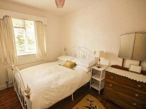 法尔卡拉Teach Annie的卧室配有白色的床、梳妆台和窗户。