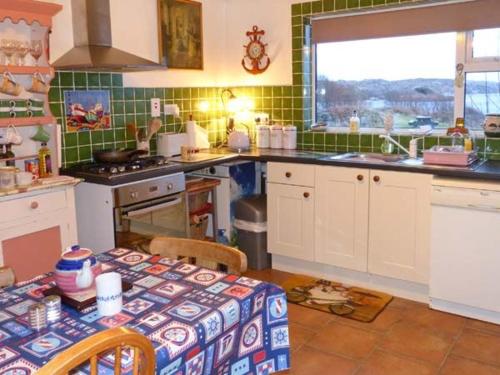 KnockThe Lake House, Connemara的厨房配有桌子、水槽和炉灶。