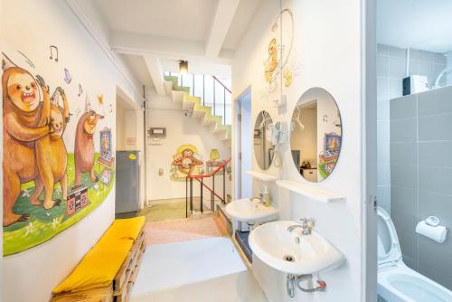 曼谷Sloth Hostel Khaosan的一间带两个盥洗盆和楼梯的浴室
