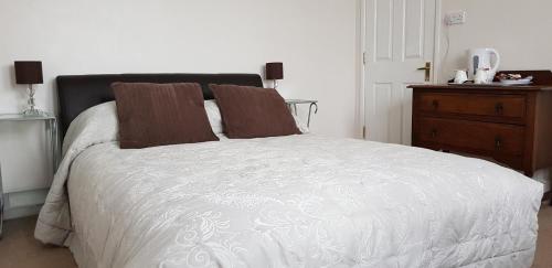 索伦特海峡旁利村Avon Manor Guest House的一间卧室配有一张白色的床和木制梳妆台