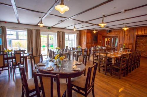 康镇Lydons Lodge Hotel的餐厅内带桌椅的用餐室