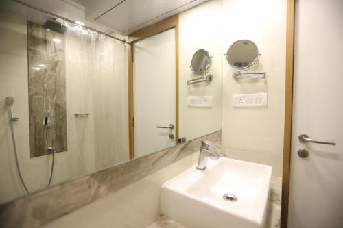 孟买星辰饭店的一间带水槽、淋浴和镜子的浴室