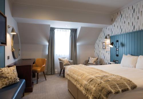 费勒姆索伦特Spa酒店 的酒店客房设有一张大床和一张书桌。