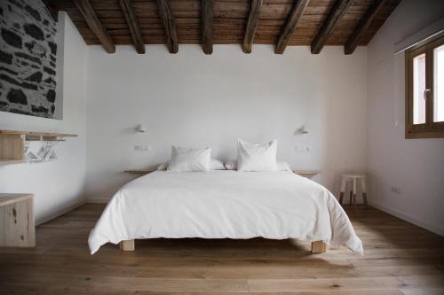 贝尔加拉Izal Landetxea的白色卧室配有一张带白色床单的大床