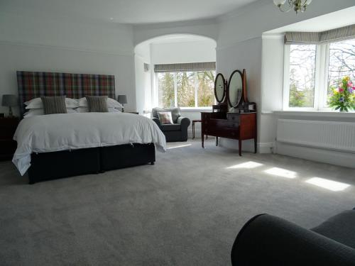 巴克斯顿Grendon Bed & Breakfast的一间卧室配有一张床、一把椅子和窗户。