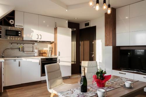 索非亚Center apartment with amazing view的厨房配有白色橱柜和1张带1瓶葡萄酒的桌子