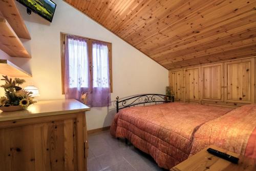 BalzeB&B fam. ACCIAI的一间卧室设有一张床和木制天花板