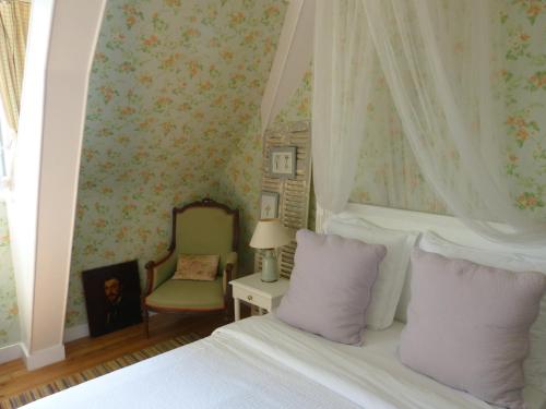 翁弗勒尔拉莉涅尔住宿加早餐旅馆的一间卧室配有一张带紫色枕头的床和一把椅子