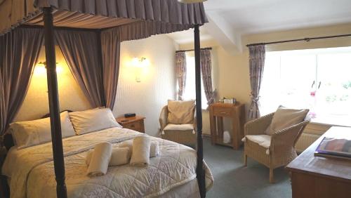 Torver维尔盖特旅馆的一间卧室配有一张天蓬床和一把椅子