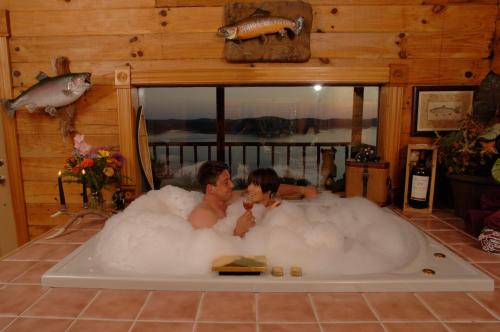 尤里卡斯普林斯Sugar Ridge Resort的两人坐在浴缸里,浴缸里装满泡沫