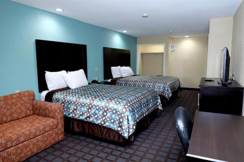 阿林顿游侠套房酒店的酒店客房,设有两张床和一张沙发