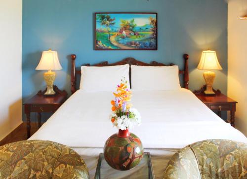 圣地亚哥Suite San Juan 135 Gran Pacifica Resort的一间卧室,配有一张带花瓶的床