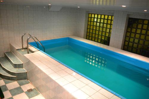 维尔纽斯耶路撒冷酒店的旁边设有楼梯的大型游泳池