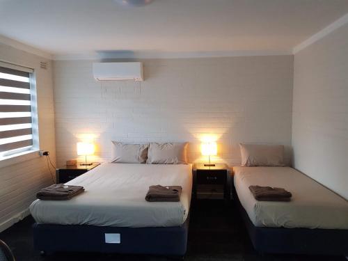 珀斯城市海洋酒店的配有两盏灯的小房间内的两张床