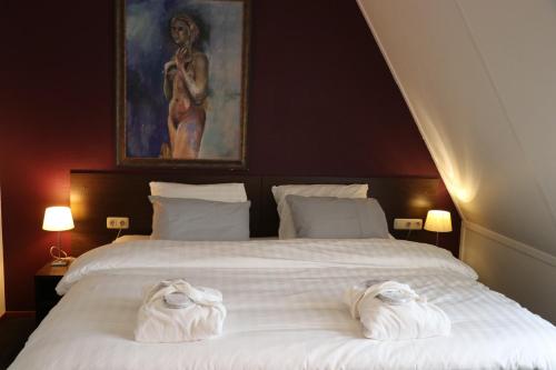 西泰尔斯海灵Wellness Suites Dellewal的一间卧室配有一张大床和毛巾