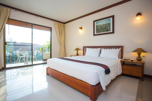 清迈清迈邦昆酒店的一间卧室设有一张大床和一个大窗户