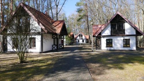鲁恰内尼达Ośrodek Szkoleniowo - Wypoczynkowy Guzianka的白色房子,有棕色的屋顶