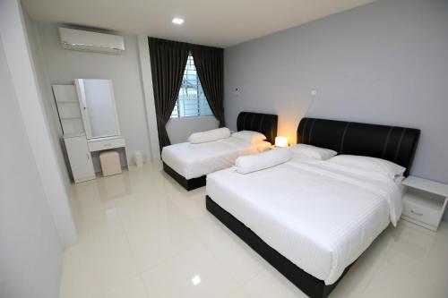 古晋722 Homestay的卧室设有2张床,拥有白色的墙壁和白色的地板