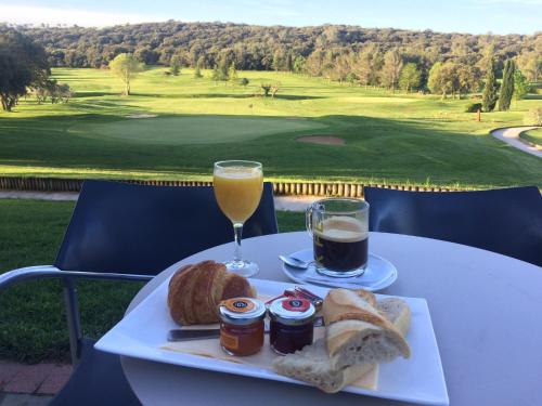 尼姆高尔夫公寓酒店的一盘食物和一杯橙汁及面包