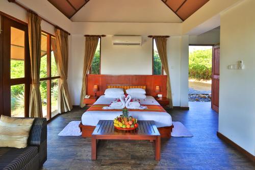 雅拉Laya Safari Resorts & Spa的一间卧室配有一张大床和一张沙发