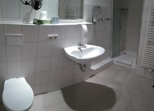 维斯马希利亚潘森酒店的白色的浴室设有卫生间和水槽。