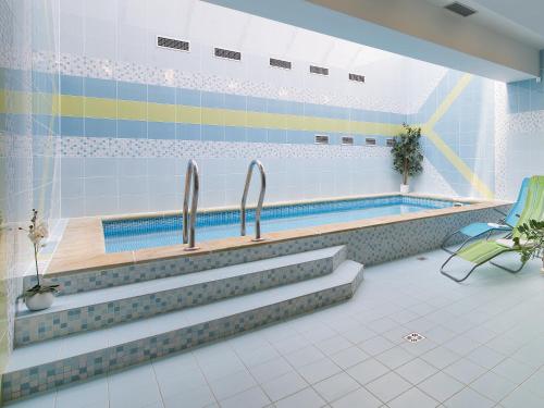 伏尔塔瓦河畔赫卢博卡波德拉德酒店的一个带两个水龙头的游泳池