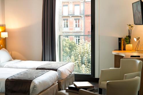 图卢兹乐佩雷莱昂酒店的酒店客房设有两张床和窗户。