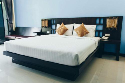 春蓬帕姆斯威特度假酒店的卧室配有带枕头的大型白色床