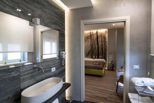 巴勒莫巴勒莫中央住宿加早餐旅馆的一间带水槽的浴室和一张位于后面的床。