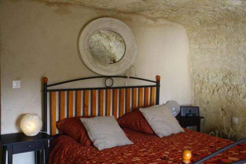 武夫赖Clos Mariotte的卧室配有一张床,墙上设有一面圆镜子