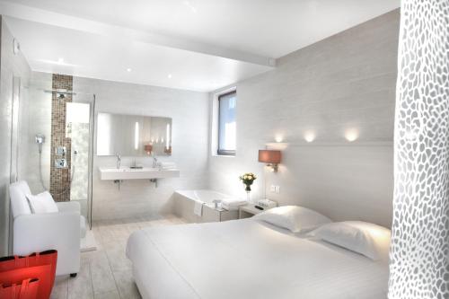 瓦尔邦讷第十七号酒店的一间带白色床的卧室和一间浴室