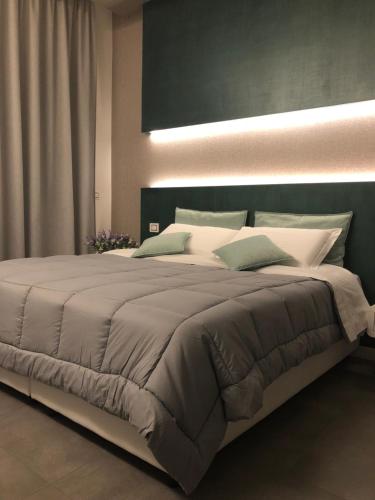 维博瓦伦蒂亚CALAMO -HOTEL -RESIDENCE- B&B的卧室内的一张大床,配有一张大床和一张大号的四柱床