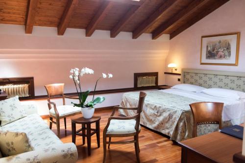 科雷焦Phi Hotel Dei Medaglioni的卧室配有一张床和一张桌子及椅子