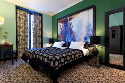 巴黎枫丹酒店的卧室配有一张床,墙上挂有绘画作品