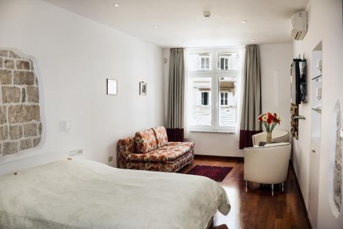 斯普利特Old Square Studio Apartment的卧室配有床、椅子和窗户。