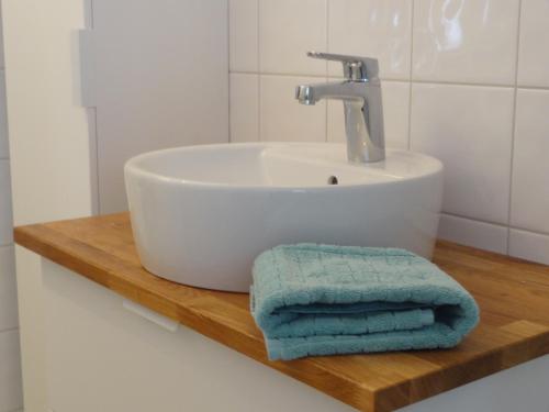 SollerönVilla gruddbo的浴室水槽和木架上的两条毛巾