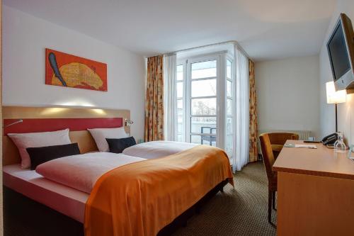 纽伦堡纽伦堡中心酒店的配有一张床和一张书桌的酒店客房