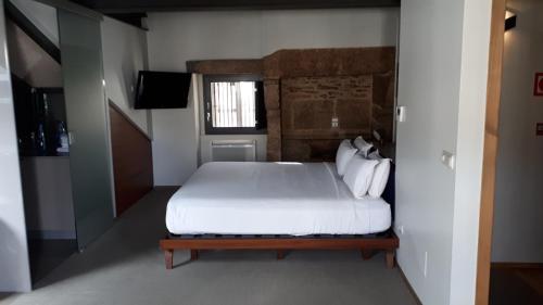 圣地亚哥－德孔波斯特拉游客布兰科公寓酒店的卧室配有白色的床和窗户。