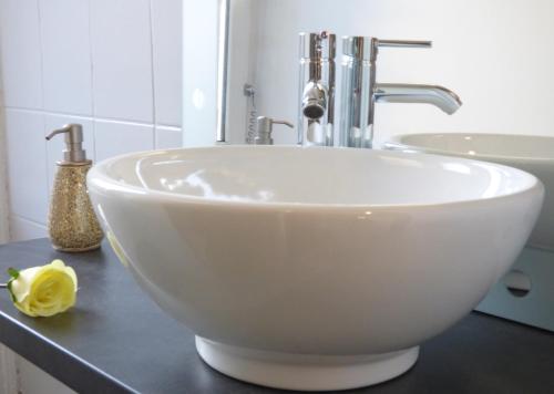 蓬托尔松Gite 7 km du Mont St Michel的浴室内一个柜台上的白色碗水槽