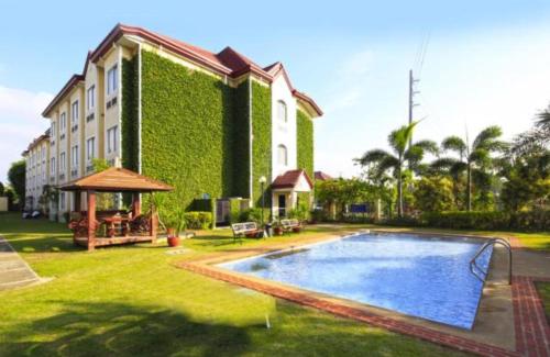 Santo Tomas文德汉姆巴塘加斯麦克罗酒店的一座大建筑,在庭院里设有一个游泳池