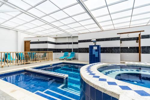 莱瓦镇Hotel El Giro的一个带蓝色椅子的酒店客房的游泳池