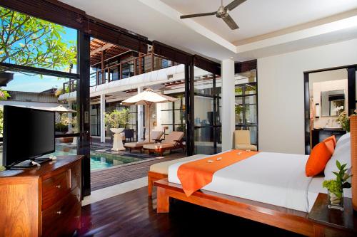 金巴兰寺山别墅酒店的一间卧室设有一张床、一台电视和一个游泳池