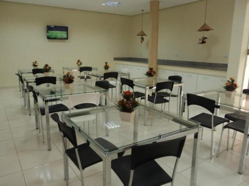 SeabraHotel Cambui的用餐室配有玻璃桌和黑色椅子