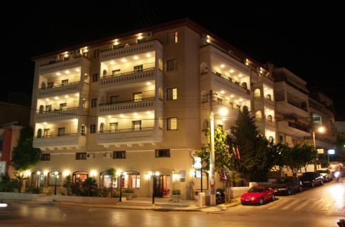 罗希姆诺叶琳娜酒店公寓的一座白色的大建筑,晚上有灯