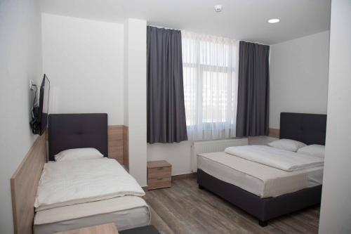 萨拉热窝Apartments R Sport boutique的一间卧室设有两张床和窗户。