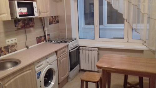 基辅Apartment on Rusanivska 16的厨房配有水槽和洗衣机