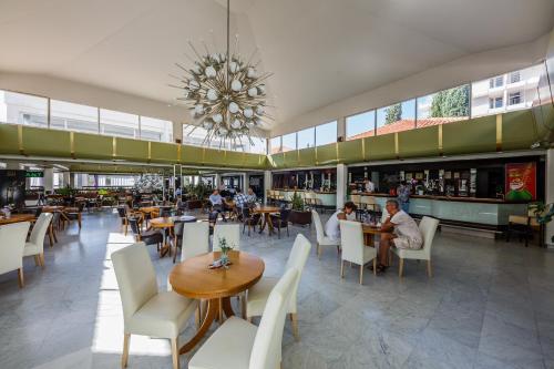 特罗吉尔Hotel Medena Budget的一间带桌椅和吊灯的餐厅