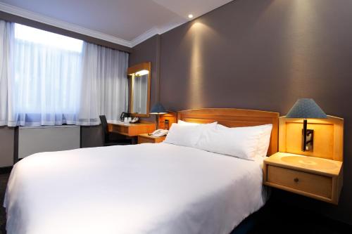 比勒陀利亚曼哈顿酒店的一间设有大床和窗户的酒店客房